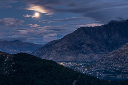 Cityscape of Queenstown at night with The Remarkables in the background from viewpoint at Queenstown Skyline, New Zealandの写真素材
