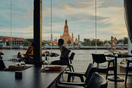 BANGKOK, THAILAND - JUL 5, 2020: The landscape of Wat Arun (Temple of Dawn) from a restaurant's window at the sunsetのeditorial素材