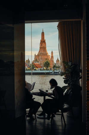BANGKOK, THAILAND - JUL 5, 2020: The landscape of Wat Arun (Temple of Dawn) from a restaurant's window at the sunsetのeditorial素材