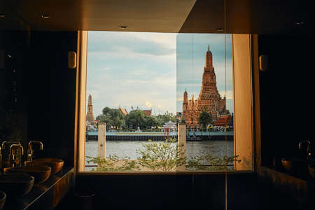 BANGKOK, THAILAND - JUL 5, 2020: The landscape of Wat Arun (Temple of Dawn) from a restaurant's window at the sunsetのeditorial素材