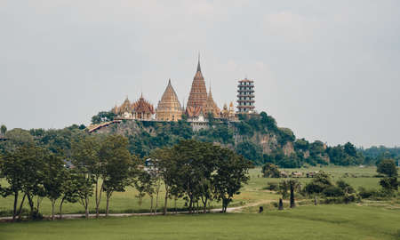 The landscape of Wat Tham Sua from a distance with rice field on a foreground, Thailandの写真素材