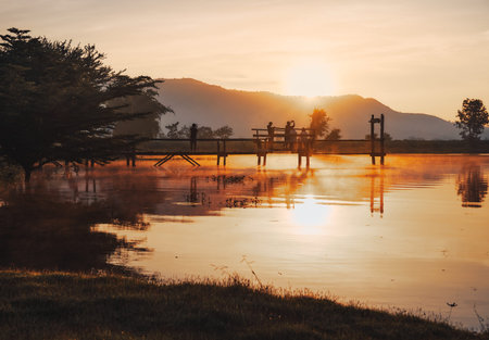 THAILAND, KANCHANABURI - OCT 24, 2019: The landscape of Lam Taphoen reservoir with tourists standing on the bridge near the reservoir at sunrise in Suphan Buri province, Thailandのeditorial素材