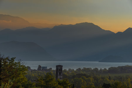 A landscape of the countryside near Iseo Lake at sunrise near the cities of Brescia. Iseo Lake also...