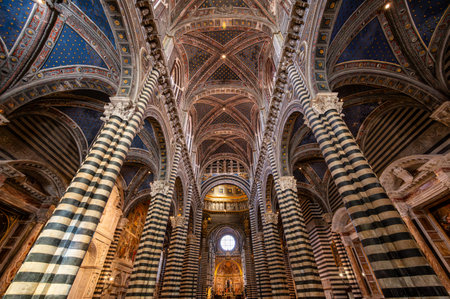 Siena, Italy - Aug 9,2023: A breathtaking interior view of Siena Cathedral, showcasing its striped columns, vaulted ceilings, and intricate marble floor designs.のeditorial素材