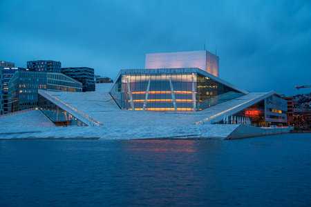 Oslo, Norway - Apr 13, 2024: A landscape of Oslo Opera House with people walking and relax around...