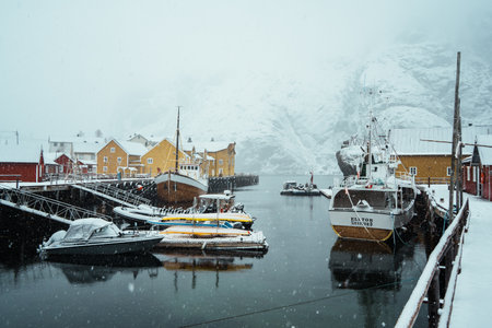 Nusfjord, Norway - Apr 7,2024: A snow-covered colorful village by a fjord in a winter landscape. Lofoten Island.の写真素材