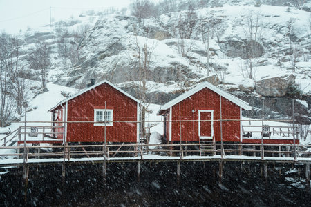 A snow-covered village by a fjord in a winter landscape.