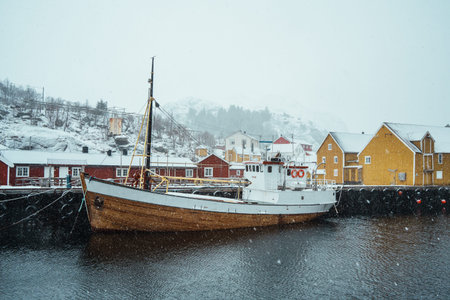 A snow-covered colorful village by a fjord in a winter landscape. Nusfjord, Lofoten.