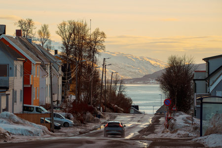 Charming winter scenes from Tromso, Norway, featuring colorful harbor buildings, boats, snow-covered...