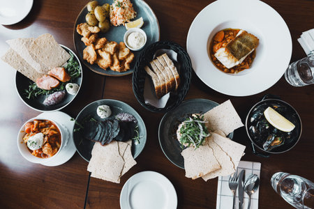 Overhead view of a variety of traditional Norwegian lunch dishes featuring seafood, root vegetables,...