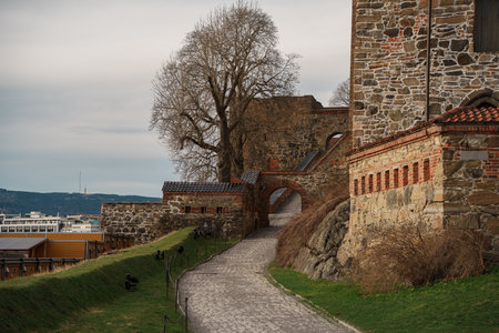 Oslo, Norway - Apr 13, 2024: Scenic views of Akershus Fortress in Oslo, Norway, with medieval architecture, walking paths, and green public spaces around historic walls.の写真素材