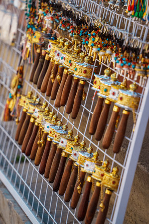 A close-up view of a display of small, ornate Tibetan prayer wheels with vibrant accents.の写真素材