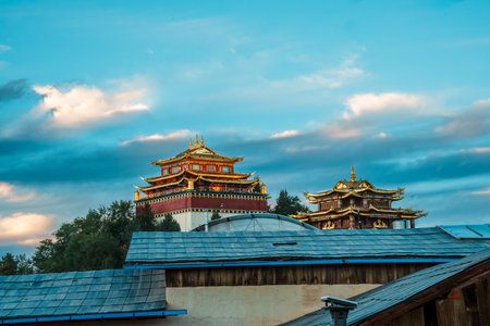 The golden roofs of Dafo Temple stand out against a beautiful sunset sky in Dukezong Ancient Town, Shangri-La, China.の写真素材