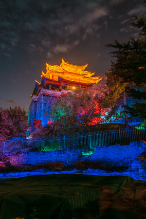 Golden light bathes the Dafo Temple on Guishan Hill against a deep blue twilight sky in Yunnan, China.の写真素材