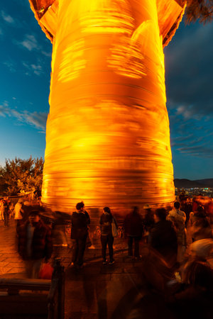 Shangri-La, China - Oct 21, 2024: Pilgrims and tourists spin the giant, glowing prayer wheel at Dafo...