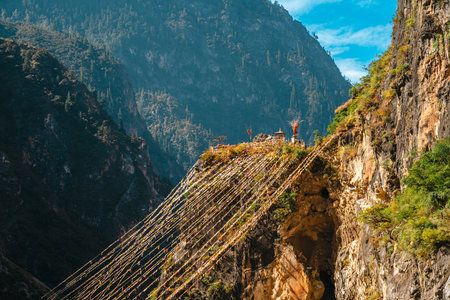 Colorful Tibetan prayer flags stretch across a dramatic, deep river canyon in the mountains of Yunnan. Balagezong, Shangri-La.の写真素材