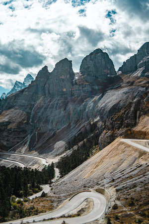 Curving mountain road cutting through forested cliffs in Balagezong National Park in Diqing, Chinaの写真素材