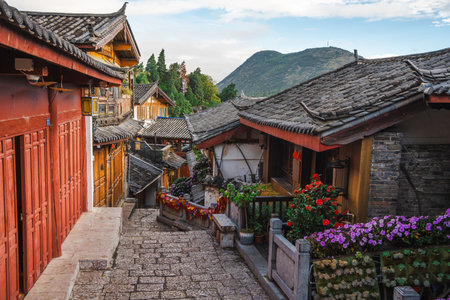 A charming stone stairway winds between wooden and brick buildings decorated with flowers in Lijiang Old Town, Yunnan.の写真素材