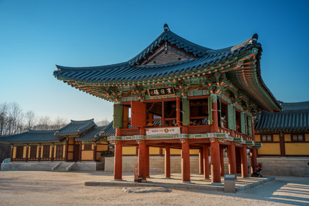 Two story pavilion at Naksansa Temple, South Korea, displays bright dancheong, curved eaves and blue tiles, rising over the courtyard in crisp afternoon light.の写真素材
