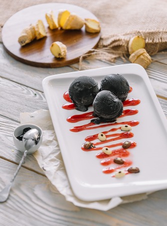 ice cream balls of different colors are on white plates in still lifeの写真素材