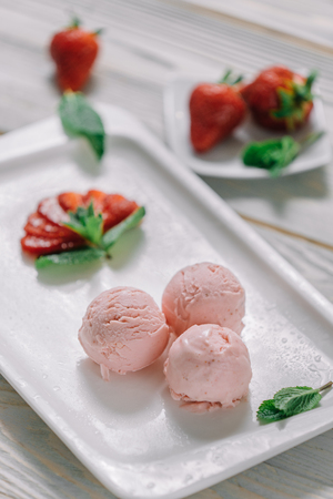 ice cream balls of different colors are on white plates in still lifeの写真素材