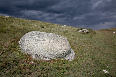 Stone in the grass against a gray sky, horizontal positionの写真素材