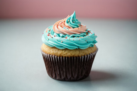 Cupcake with cream frosting on a pink and blue backgroundの素材