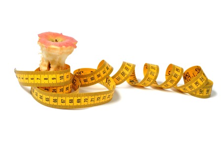 Bitten apple and measure tape over whiteの写真素材