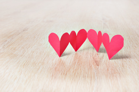 Red paper hearts on oak wooden floorの写真素材