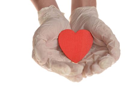 Hearts in hand with rubber gloves isolated on whiteの写真素材