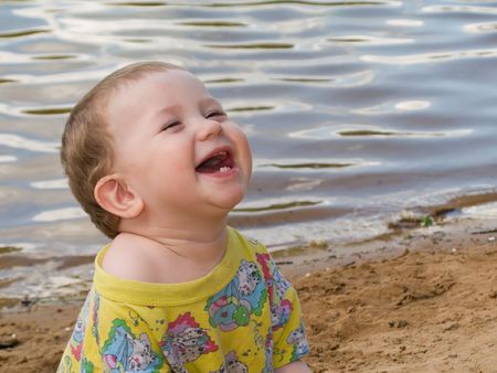 Little child smiling on water beach at summerの写真素材