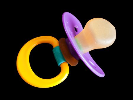 Plastic baby pacifier or soother isolated on black