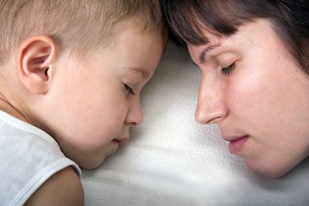 Sleeping mother and cute child in family love lifeの写真素材