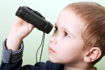 Little child boy looking binoculars lens isolatedの写真素材