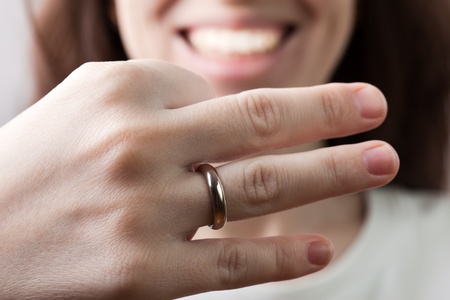 Women hand holding just married gold wedding ringの写真素材