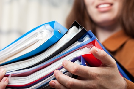 Paperwork - human hand holding business paper fileの写真素材