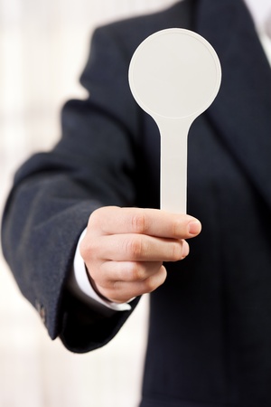 Human hand holding auction paddle voting card signの写真素材