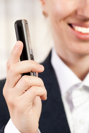 Smiling business women hand holding mobile phoneの写真素材