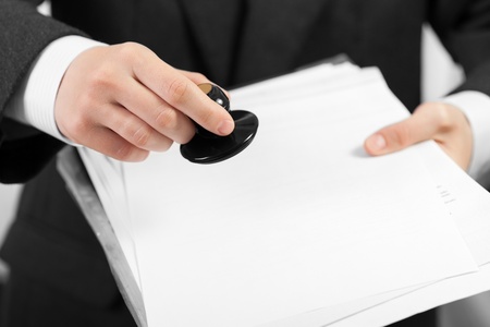 Business men hand hold office paper document stampの写真素材
