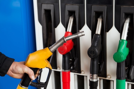 Human hand holding gasoline station gas fuel pumpの写真素材