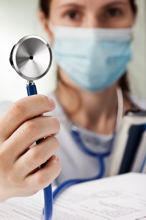 Women doctor in mask hand hold medical stethoscopeの写真素材
