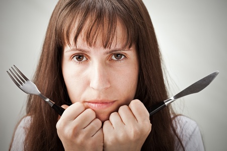 Hungry woman hand holding fork and knifeの写真素材