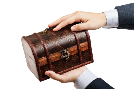 Business man hand holding old antique brown wood treasure chest or box white isolatedの写真素材