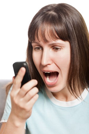 Amazed or surprised woman holding mobile phone in hand and angry screamingの写真素材