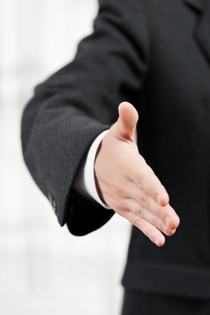 Businessman in black suit gesturing hand greeting or meeting handshakeの写真素材