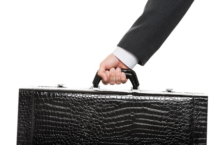 Business man in black suit hand holding large travel luggage suitcaseの写真素材