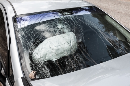 Road accident crash damaged car or wreck broken vehicle with used airbagの写真素材