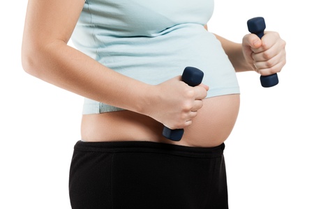 Pregnant woman exercising fitness dumbbell weights for healthy lifestyleの写真素材
