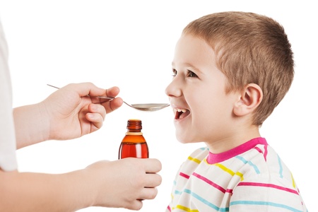 Doctor hand giving spoon dose of medicine liquid drinking syrup to child boy patientの写真素材