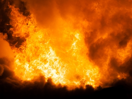 Arson or nature disaster - burning fire flame on wooden house roofの写真素材